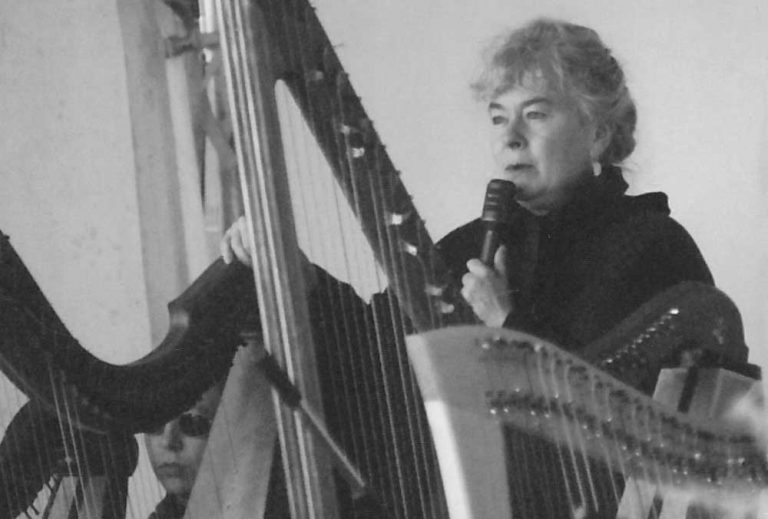 Mary Muckle behind her harp, playing with the Ottawa Youth Harp Ensemble